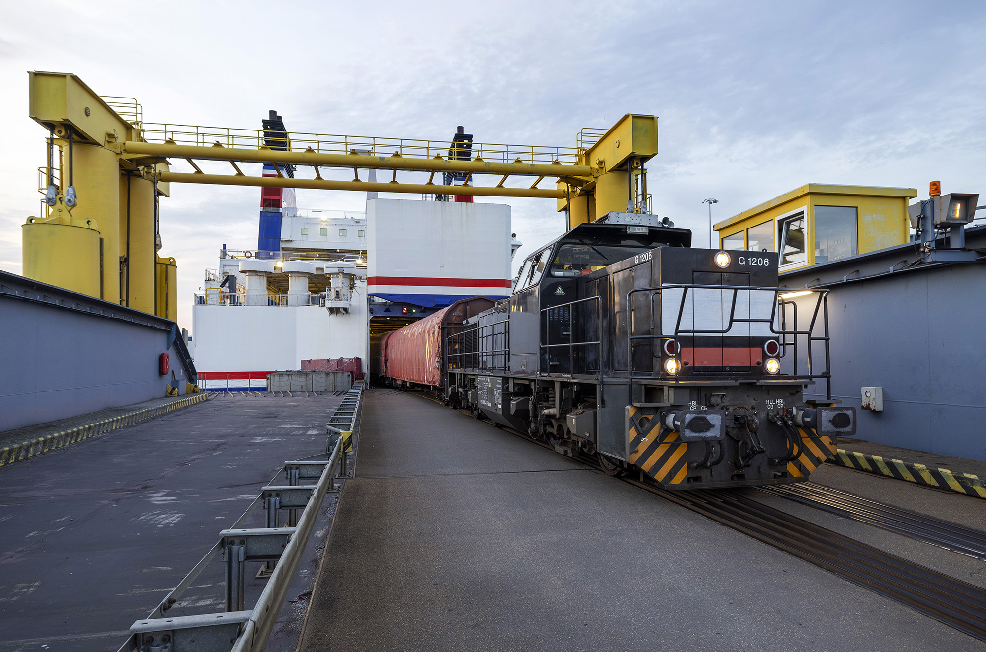 Losning af jernbanevogne fra Stena Lines færge M/S Skåne i Rostcok 2026 07 11. Vogne med stål trækkes i land af den tyske operatør HSL, med et af deres G1206 diesellokomotiver indlejet fra Northrail.